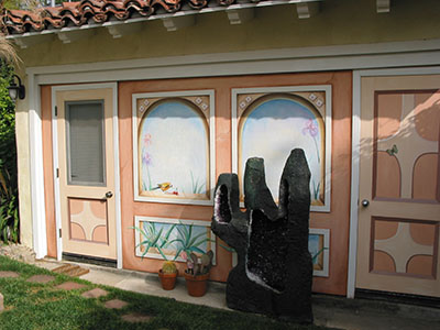 Mural painted in California Mission style as a backdrop to a geode in the shape of a cactus