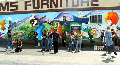 San Fernando High students practicing a performance piece in front of the mural